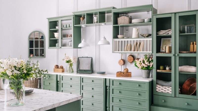 Big white kitchen with green furniture.